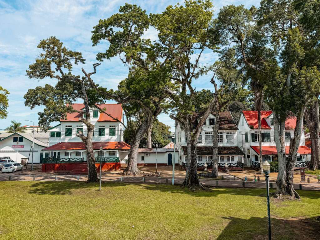 A group of colonial buildings behind a park in Suriname