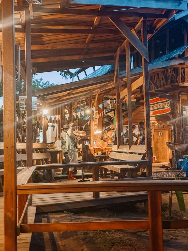 People playing instruments under a wooden pergola within a community
