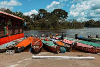 Colorful wooden boats lined up on the shore of a river in Suriname
