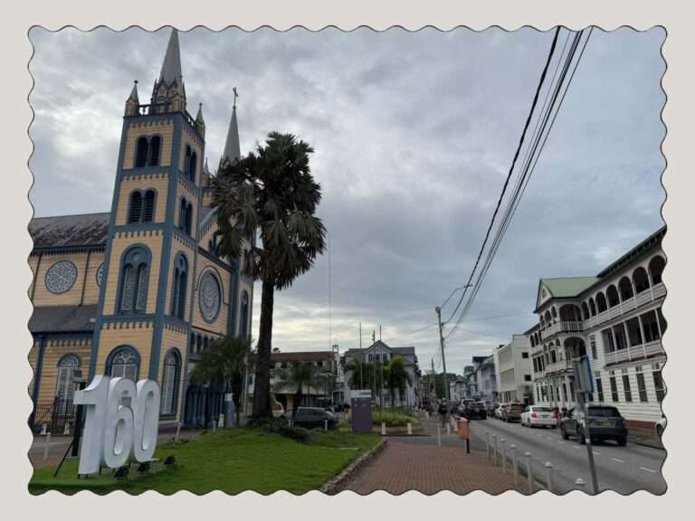 Looking down a street in Suriname with a yellow and blue wooden church on one side
