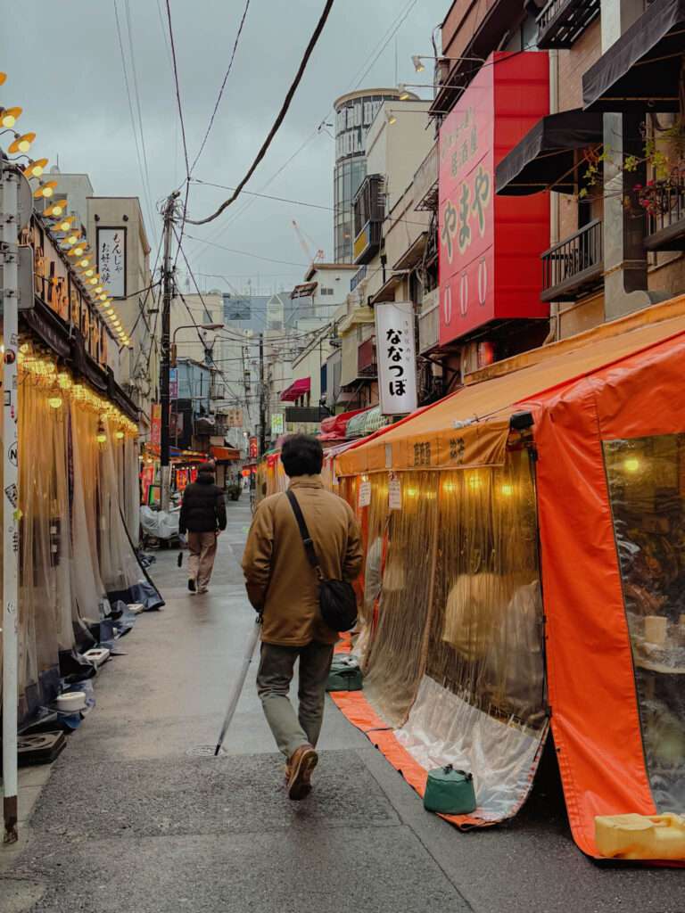 A man walking in the Rokku entertainment district of Asakusa is lined with small izakayas in Tokyo