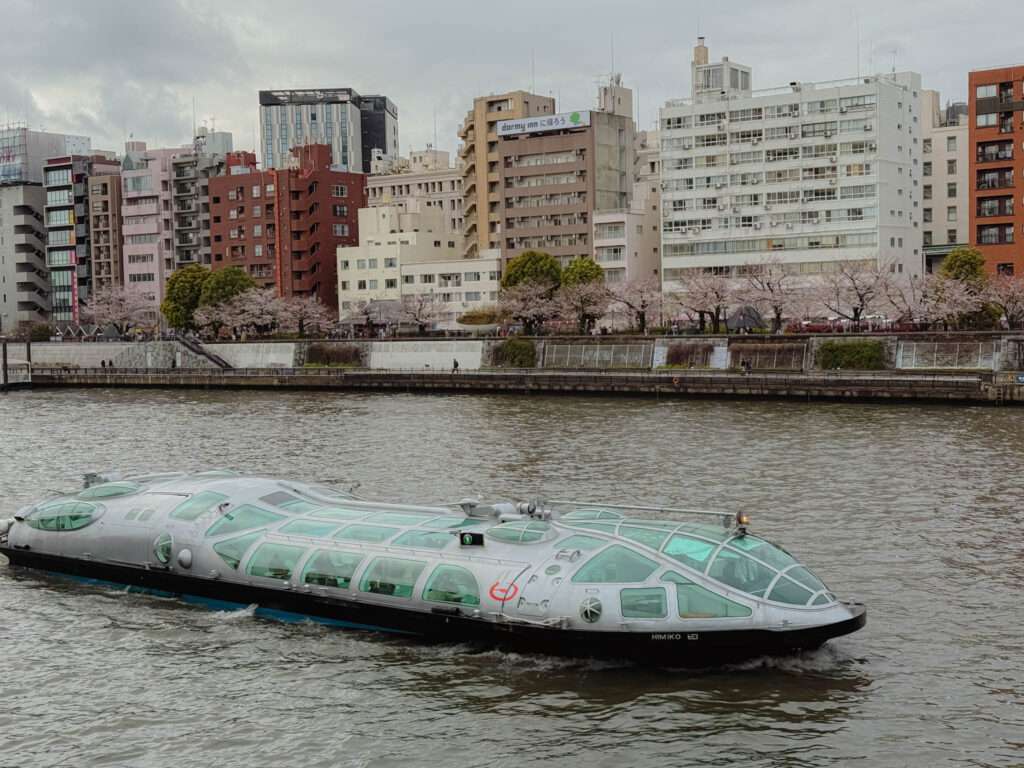 A glass-top futuristic boat navigating the river in Tokyo