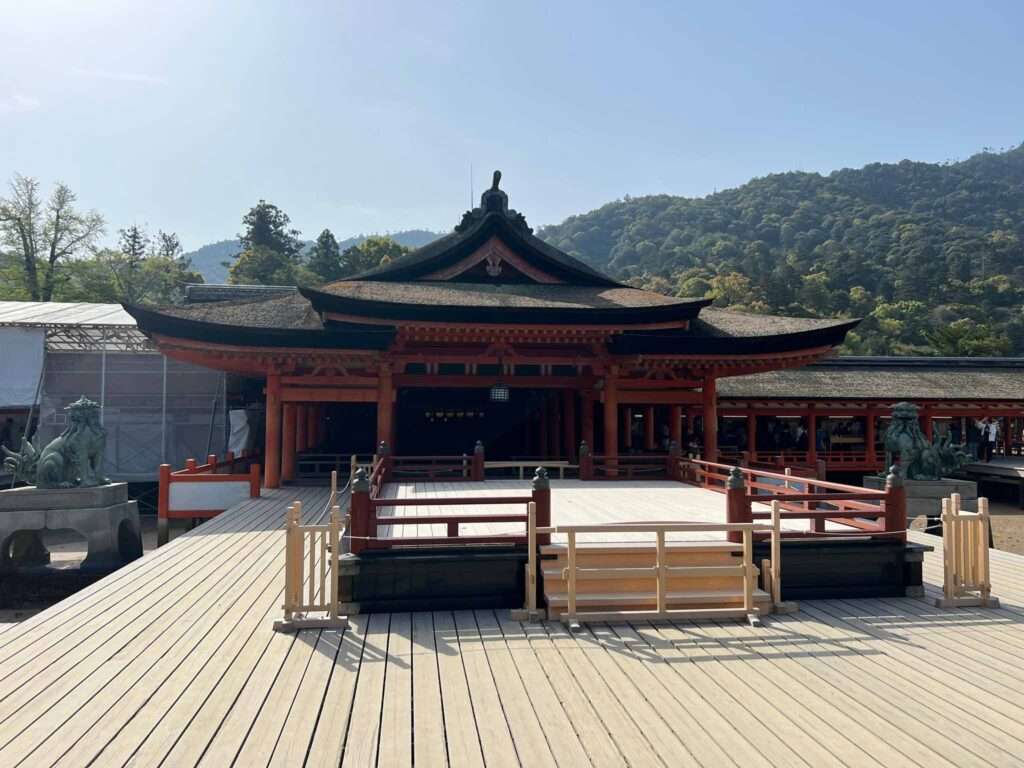 A red temple in Japan surrounded by forested hills
