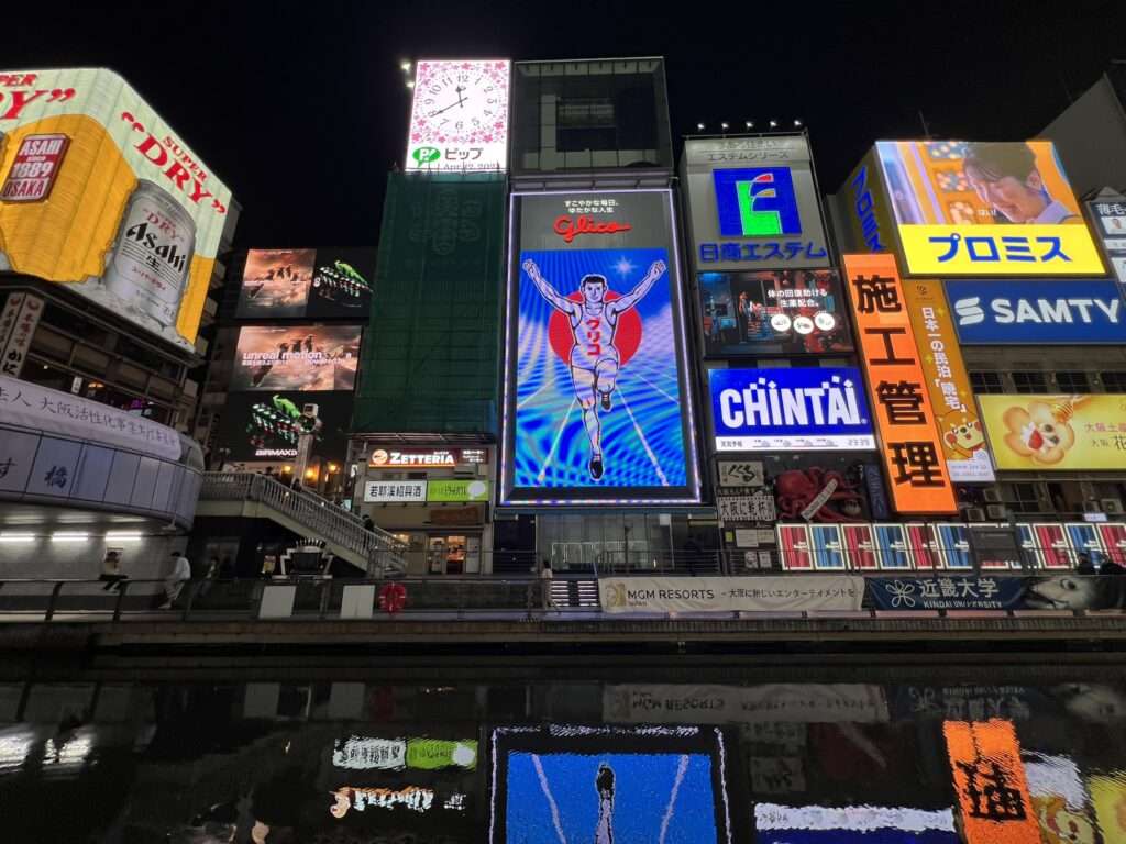 A wall of buildings with large billboards in Osaka, Japan