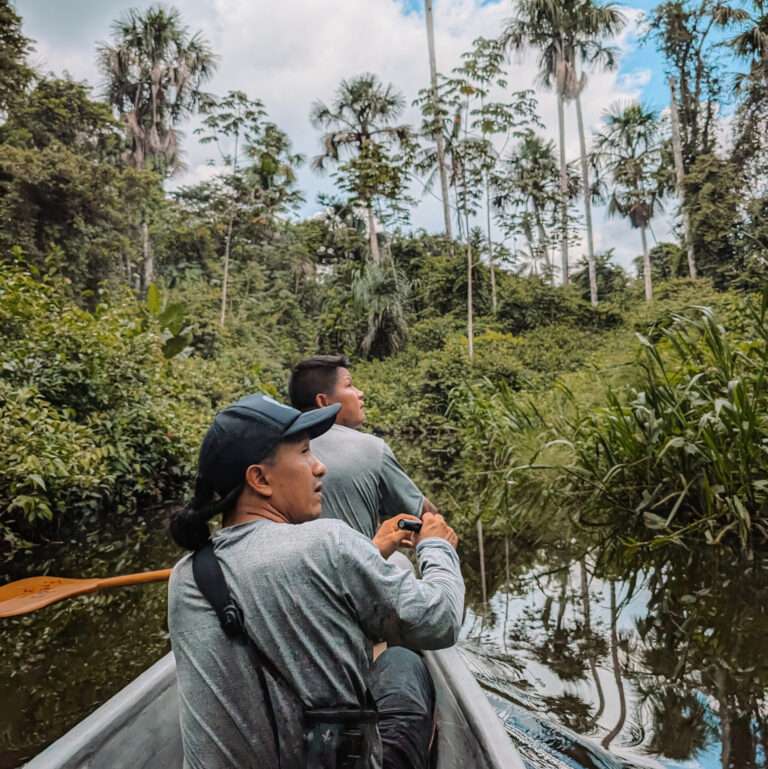 Two people rowing a canoe through the Amazon as part of an Amazon resort's offerings
