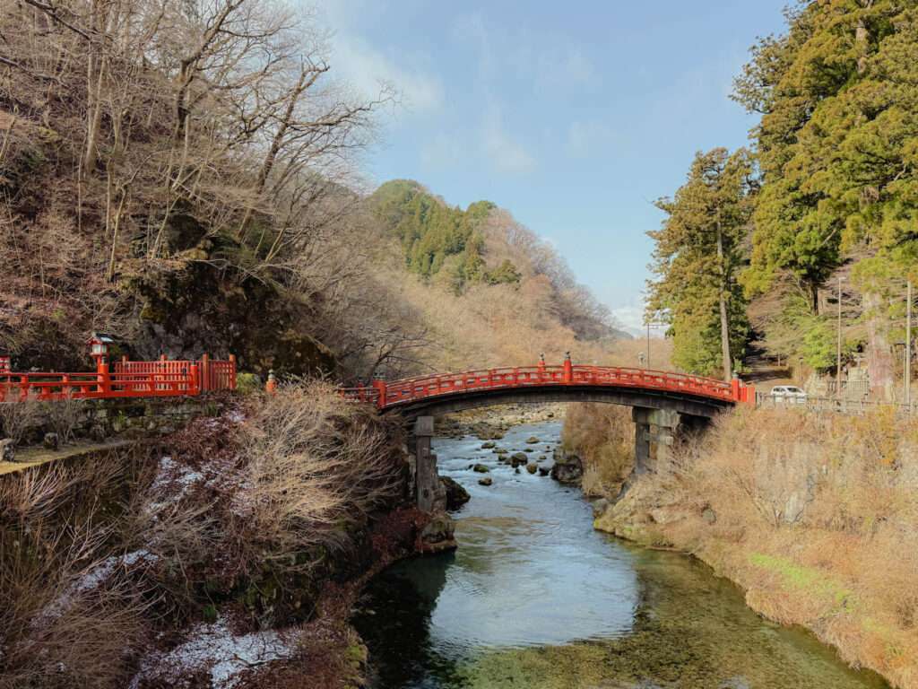 The view of the red bridge going over the river at the entrance to Nikko