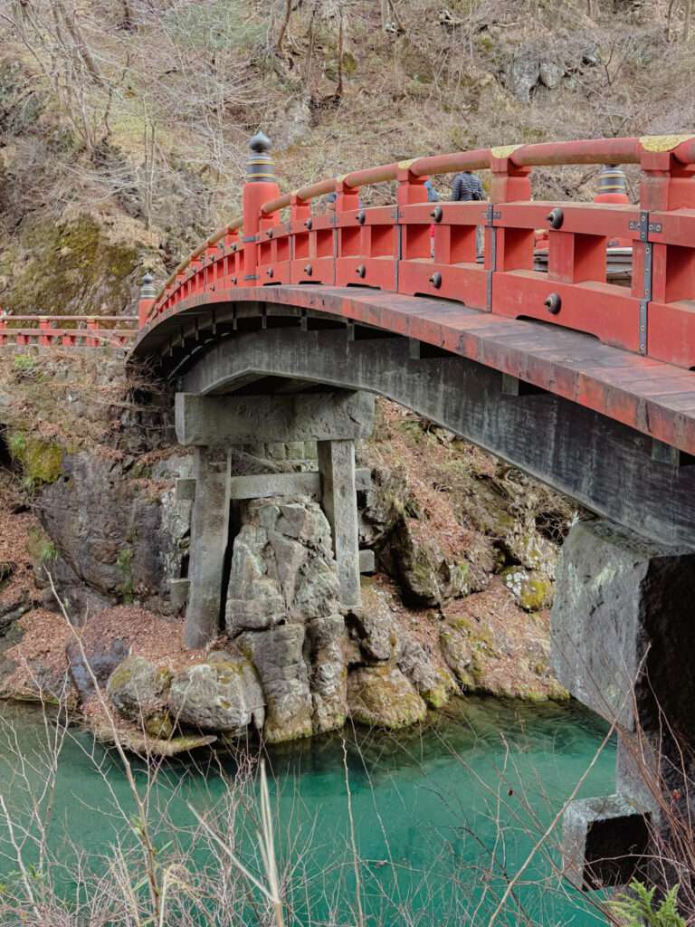 A red bridge going over a turquoise river and the first think you see when dong a day trip to NIkko