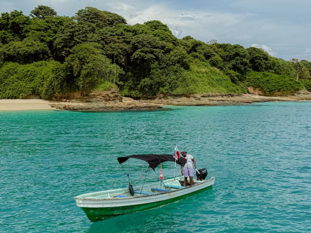 Local fishing boat anchored in turquoise water off a forested island in the Las Perlas archipelago, Panama