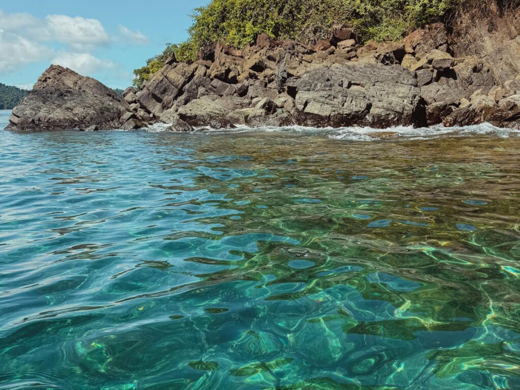 Crystal clear turquoise water and rocky coastline at Coiba National Park, Panama