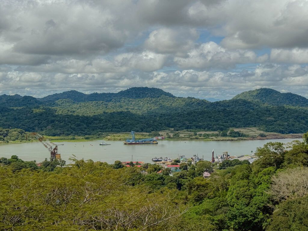 View over the Panama Canal waterway from the Gamboa area with industrial port facilities and jungle-covered hills, Panama -- day trips from Panama City