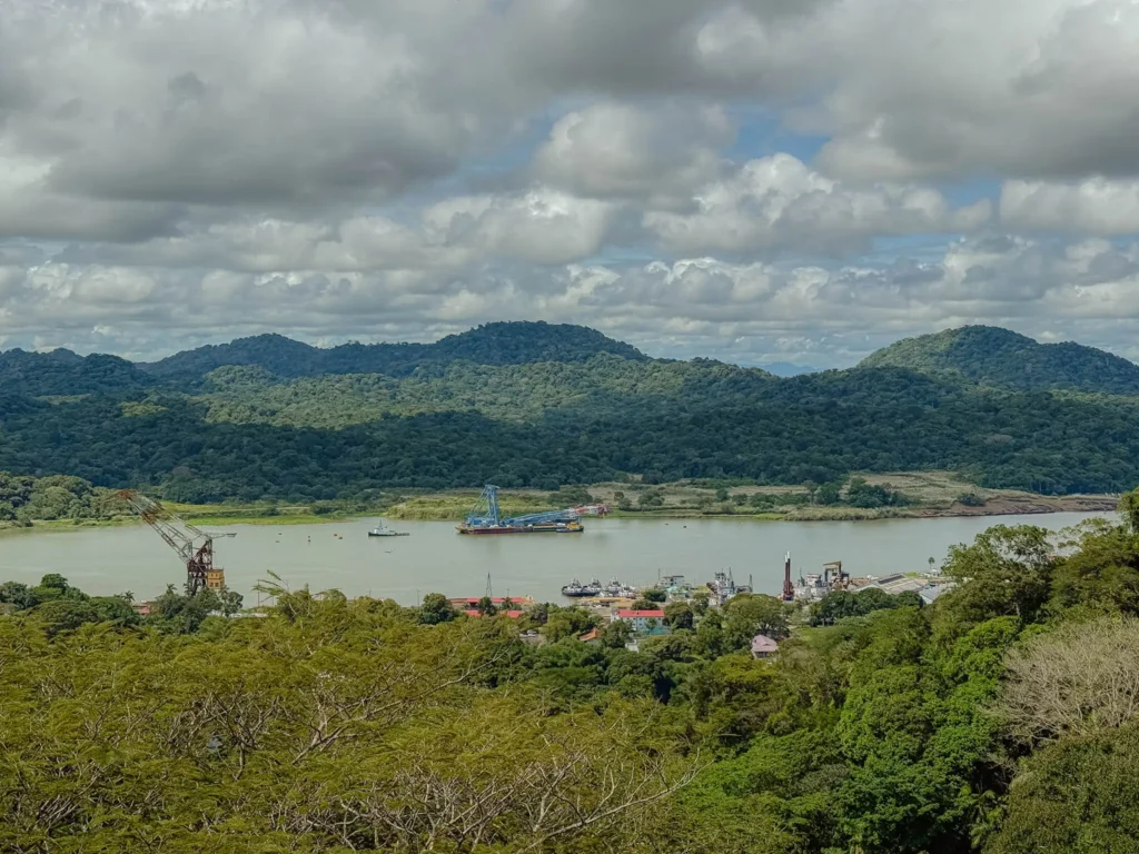 View over the Panama Canal waterway from the Gamboa area with industrial port facilities and jungle-covered hills, Panama -- day trips from Panama City