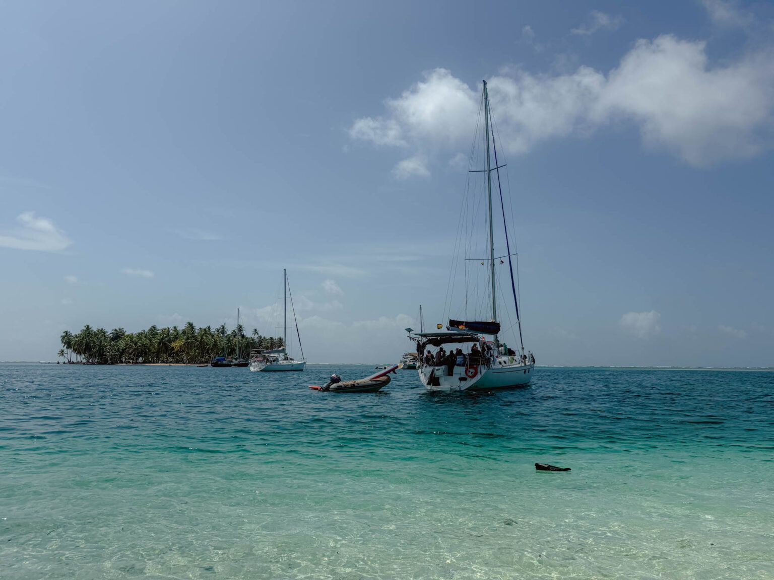Sailboat anchored in turquoise water off a palm-lined San Blas island, Guna Yala, Panama -- day trips from Panama City