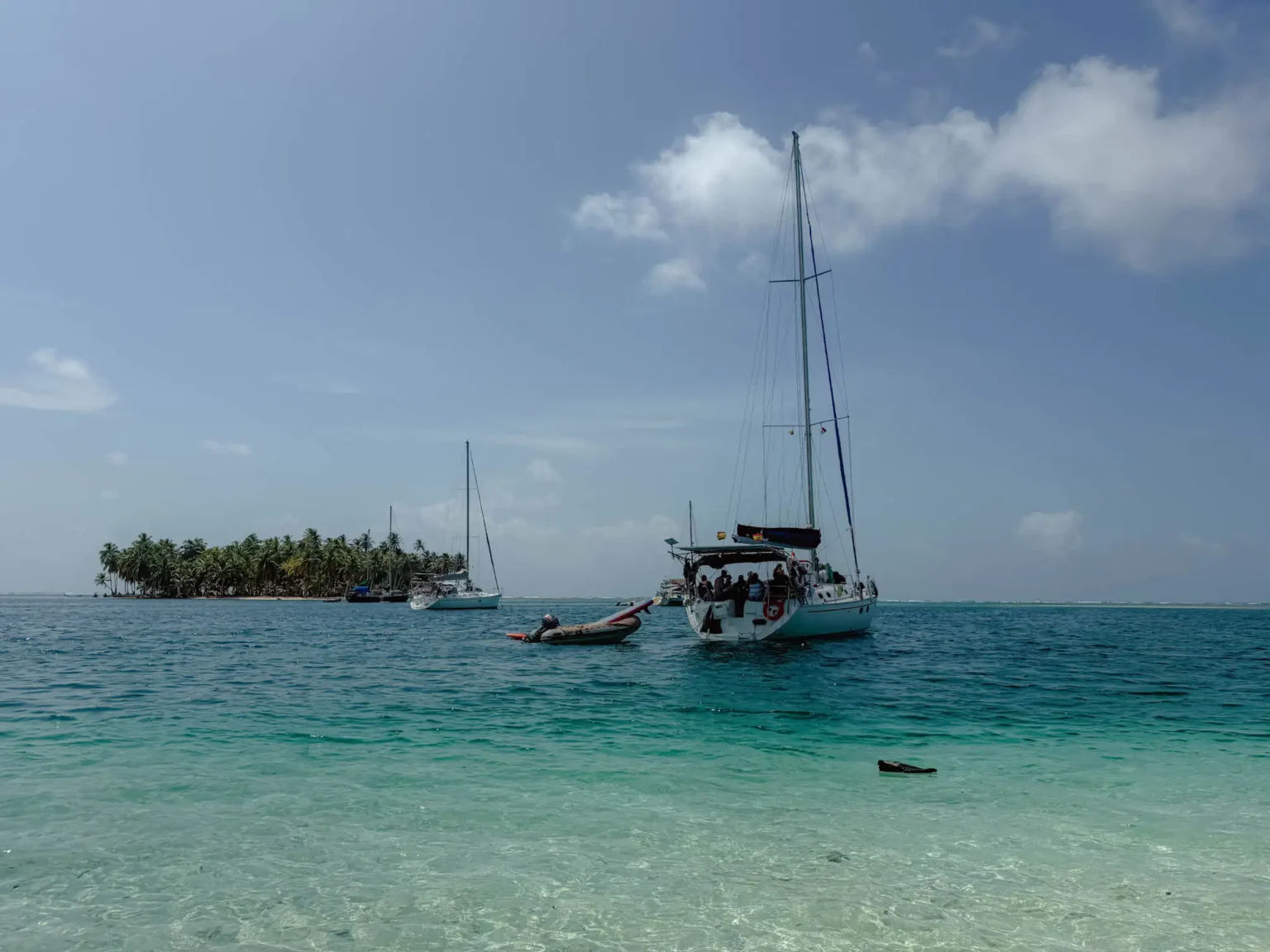 Sailboat anchored in turquoise water off a palm-lined San Blas island, Guna Yala, Panama -- day trips from Panama City