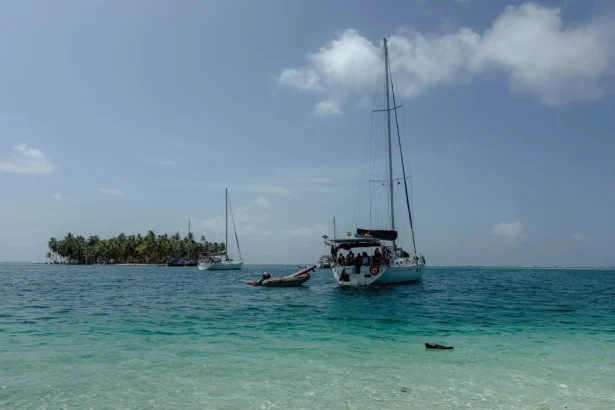 Sailboat anchored in turquoise water off a palm-lined San Blas island, Guna Yala, Panama -- day trips from Panama City
