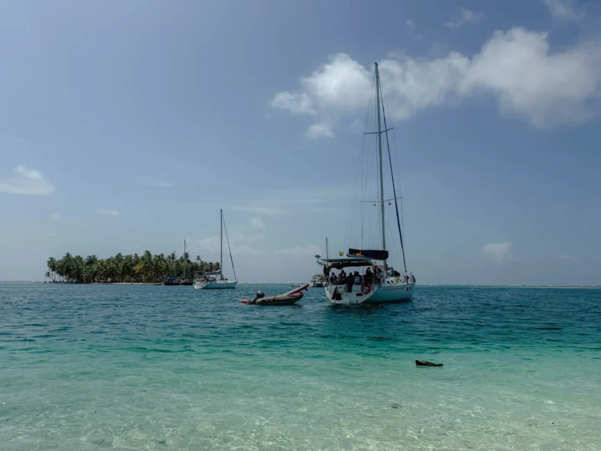 Sailboat anchored in turquoise water off a palm-lined San Blas island, Guna Yala, Panama -- day trips from Panama City