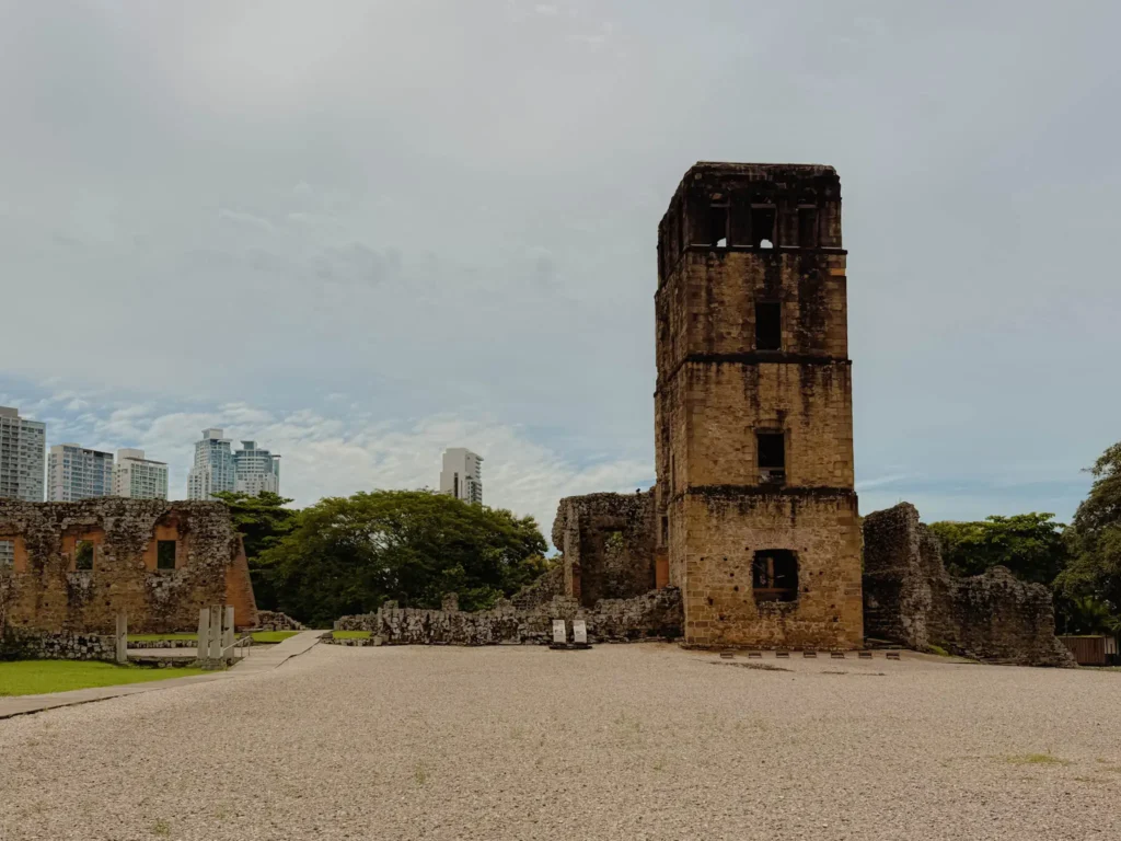 The stone cathedral tower at Panama Viejo ruins with the Panama City financial district skyline behind — Panama Viejo ruins