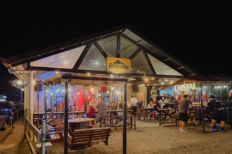 Lively outdoor seating area at Boquete Brewing Company lit up at night with string lights and guests dining -- Boquete Panama
