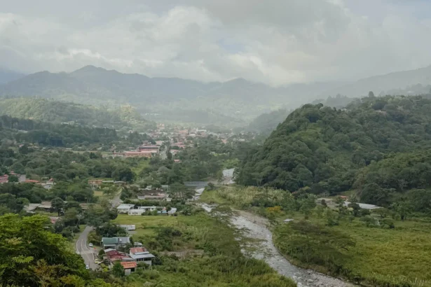 Aerial view of Boquete town nestled in a lush green valley with a river winding through and misty mountains in the background -- Boquete Panama