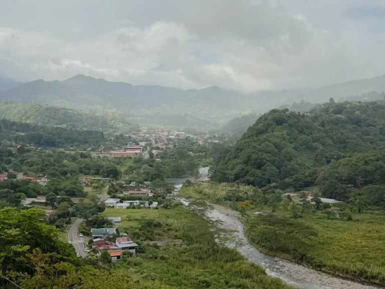 Aerial view of Boquete town nestled in a lush green valley with a river winding through and misty mountains in the background -- Boquete Panama