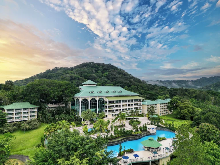 Aerial view of the Gamboa Rainforest Resort with its curved pool and rainforest hillside at golden hour -- Portobelo Panama