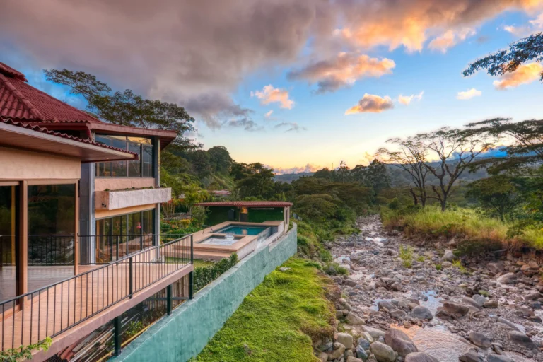 Riverside boutique hotel with an infinity pool and rocky riverbank at sunset at The Inn at Palo Alto in Boquete Panama -- Boquete Panama