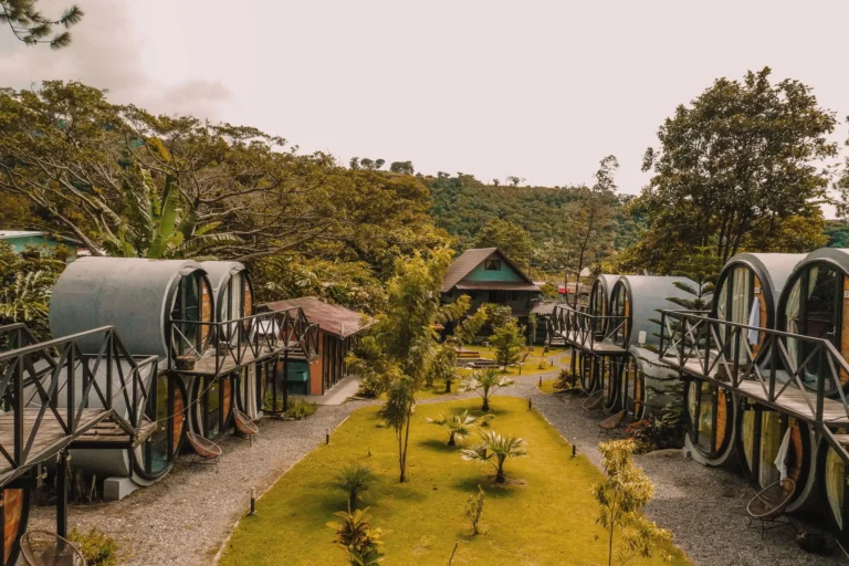 Unique barrel-shaped guest rooms lining a garden pathway surrounded by tropical trees at ONDA Boquete in Panama -- Boquete Panama