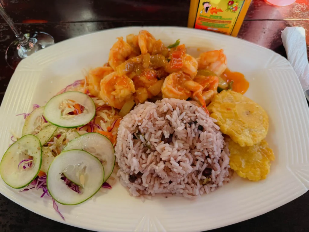 A plate of Caribbean shrimp in tomato sauce with coconut rice and patacones served in Bocas del Toro, Panama - Panama food guide