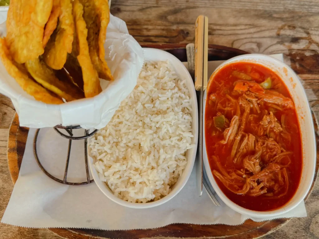 A serving of ropa vieja shredded beef stew with white rice and tostones at a Panamanian restaurant - Panama food guide