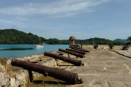 Iron cannons on the ramparts of Fort San Felipe overlooking Portobelo bay and jungle hills -- Portobelo Panama