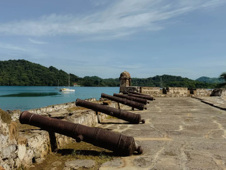 Iron cannons on the ramparts of Fort San Felipe overlooking Portobelo bay and jungle hills -- Portobelo Panama