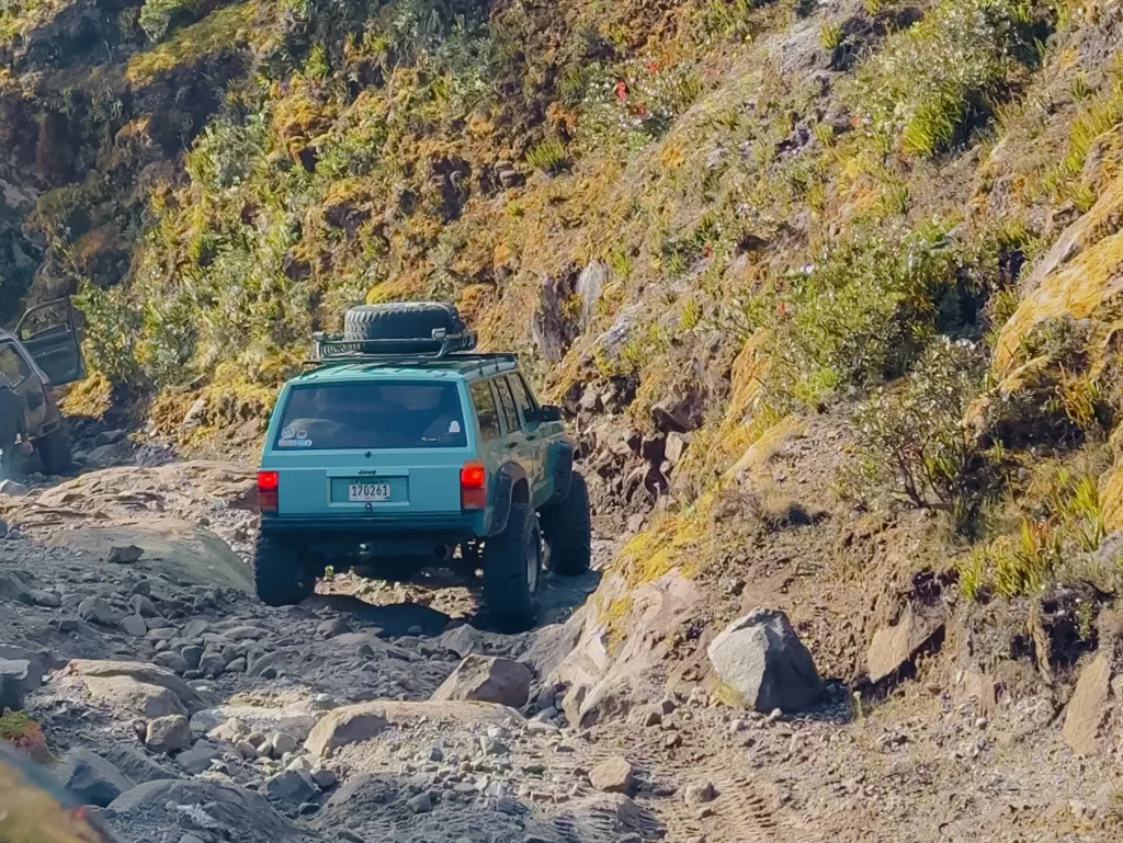 Teal Jeep Cherokee navigating the rocky volcanic road up Volcan Baru - Volcan Baru 4x4 tour