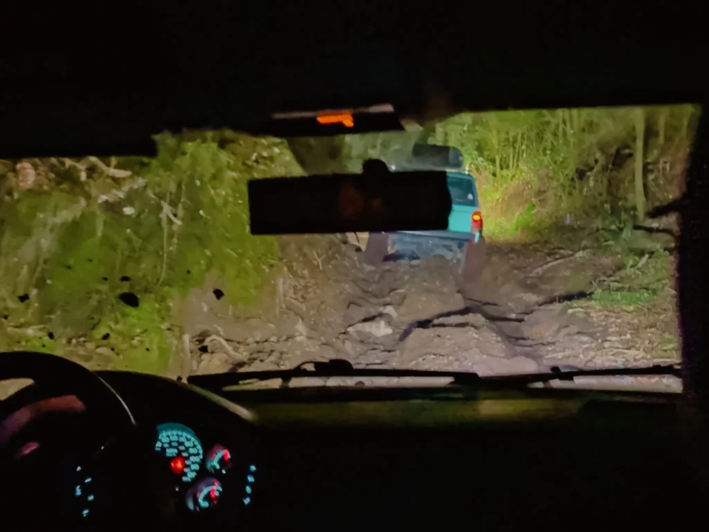 Nighttime view through the windshield of a 4x4 climbing the rocky road up Volcan Baru in the dark - Volcan Baru 4x4 tour