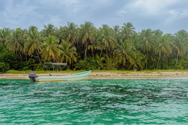 Best beaches in Bocas del Toro Panama: boat on the sand and vivid turquoise water at Cayos Zapatilla in the National Marine Park