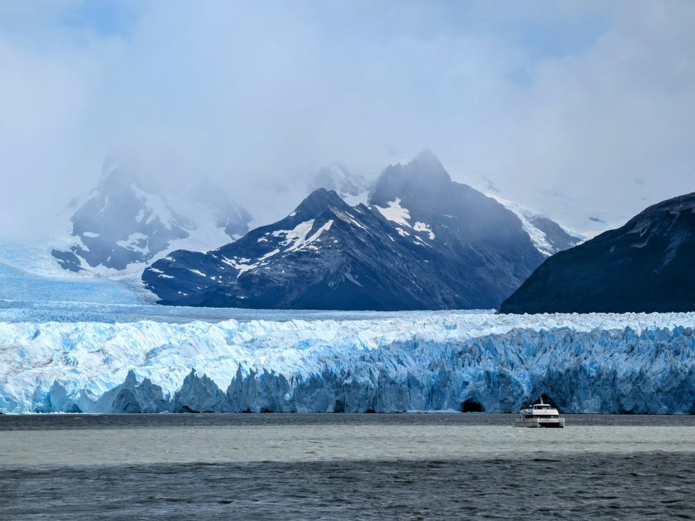 Boat in front of a glacier in front of a mountain - bus through southern patagonia