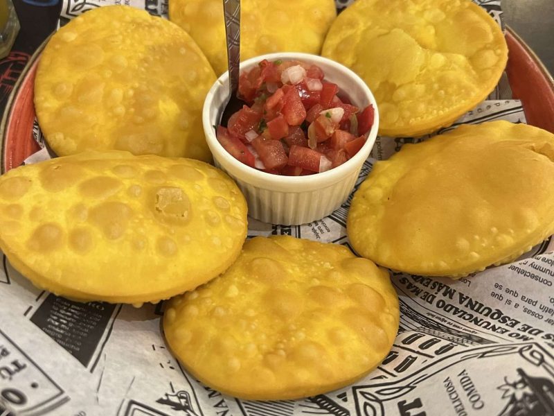 A platter of chip-like food around a salsa - Chile food