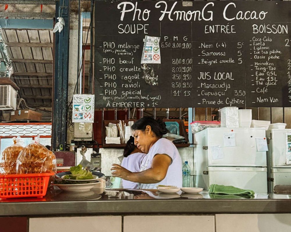 French Guiana – Cayenne-13 A woman at the counter of a Pho stand in a market that you can see when you visit the Guianas with Travel the Guianas