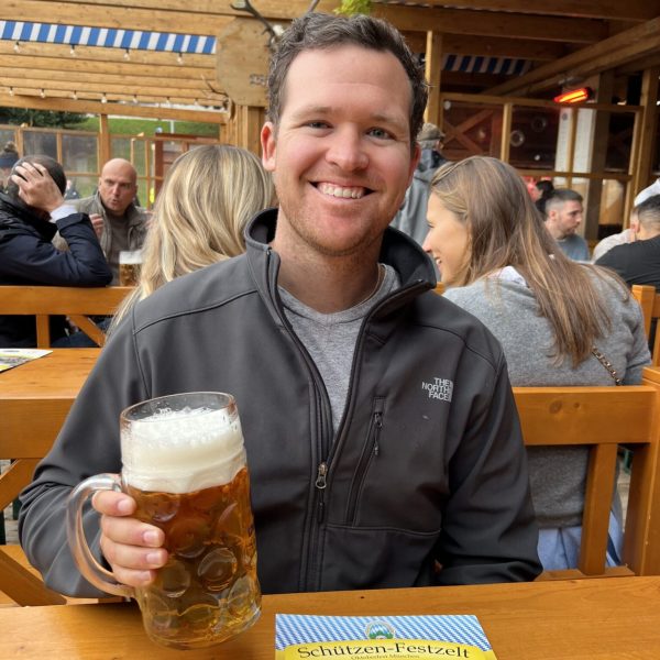 A man smiling and holding a beer