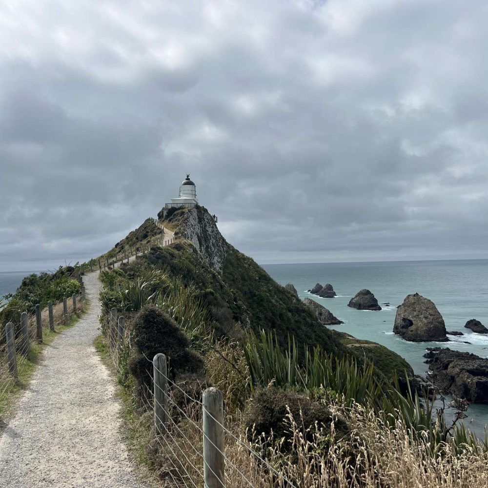 A lighthouse at the end of a path on the route to Milford Sound