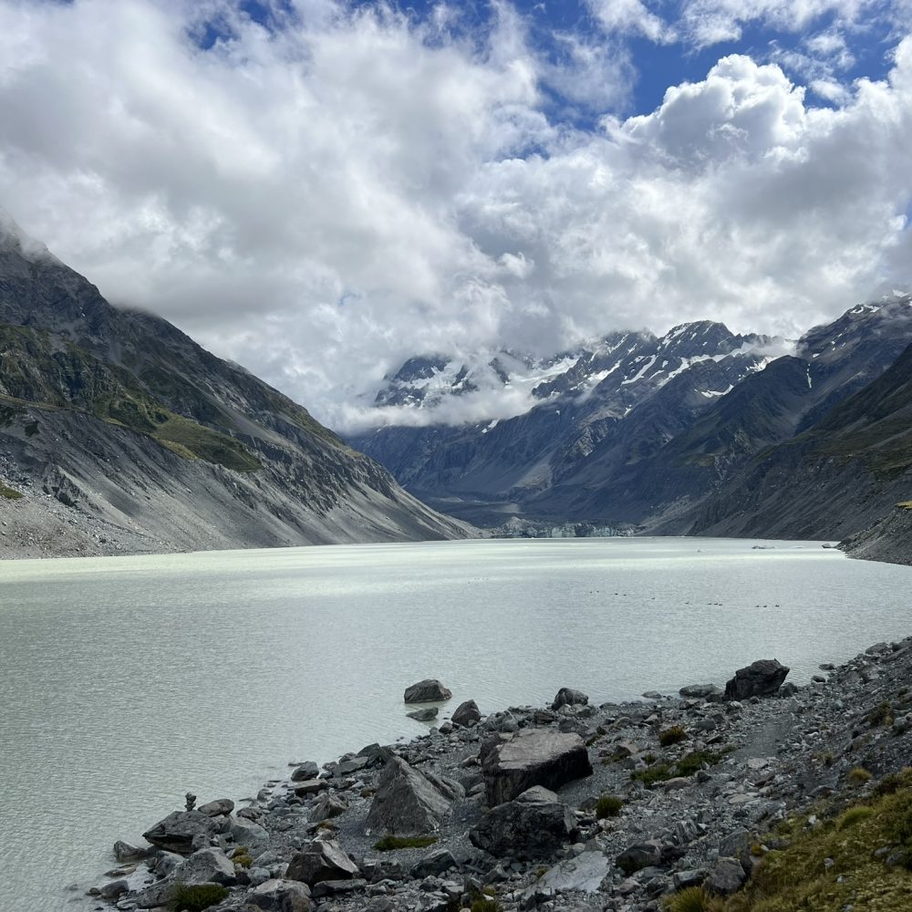 New Zealand-Mount Cook-Christchurch-Dunedin-9 A large grey lake surrounded by mountains on a trip from Christchurch to New Zealand