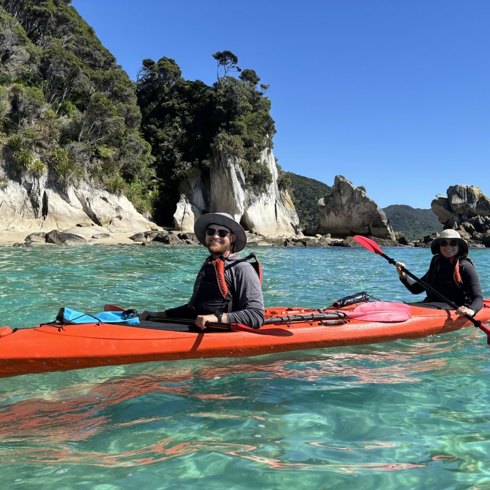 Two people in a kayak in turquoise clear water in Abel Tasman National Park