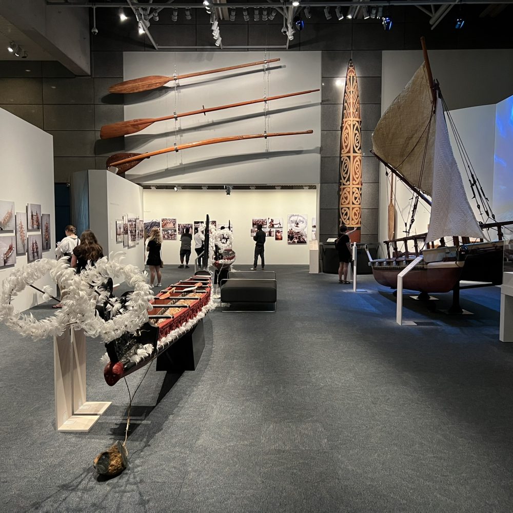 A large room with large wooden artifacts, including a canoe and paddles in New Zealand's capital city