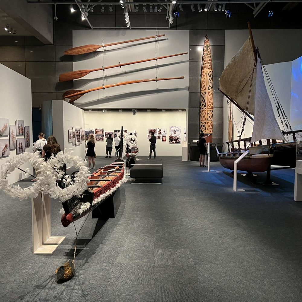 A large room with large wooden artifacts, including a canoe and paddles in New Zealand's capital city
