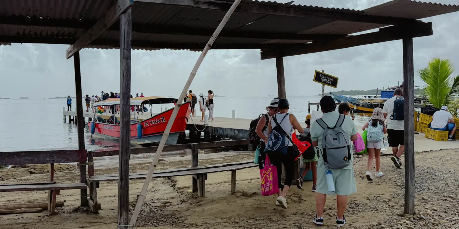 Travelers boarding colorful boats at the Carti dock to reach the San Blas Islands - how to get to San Blas Panama