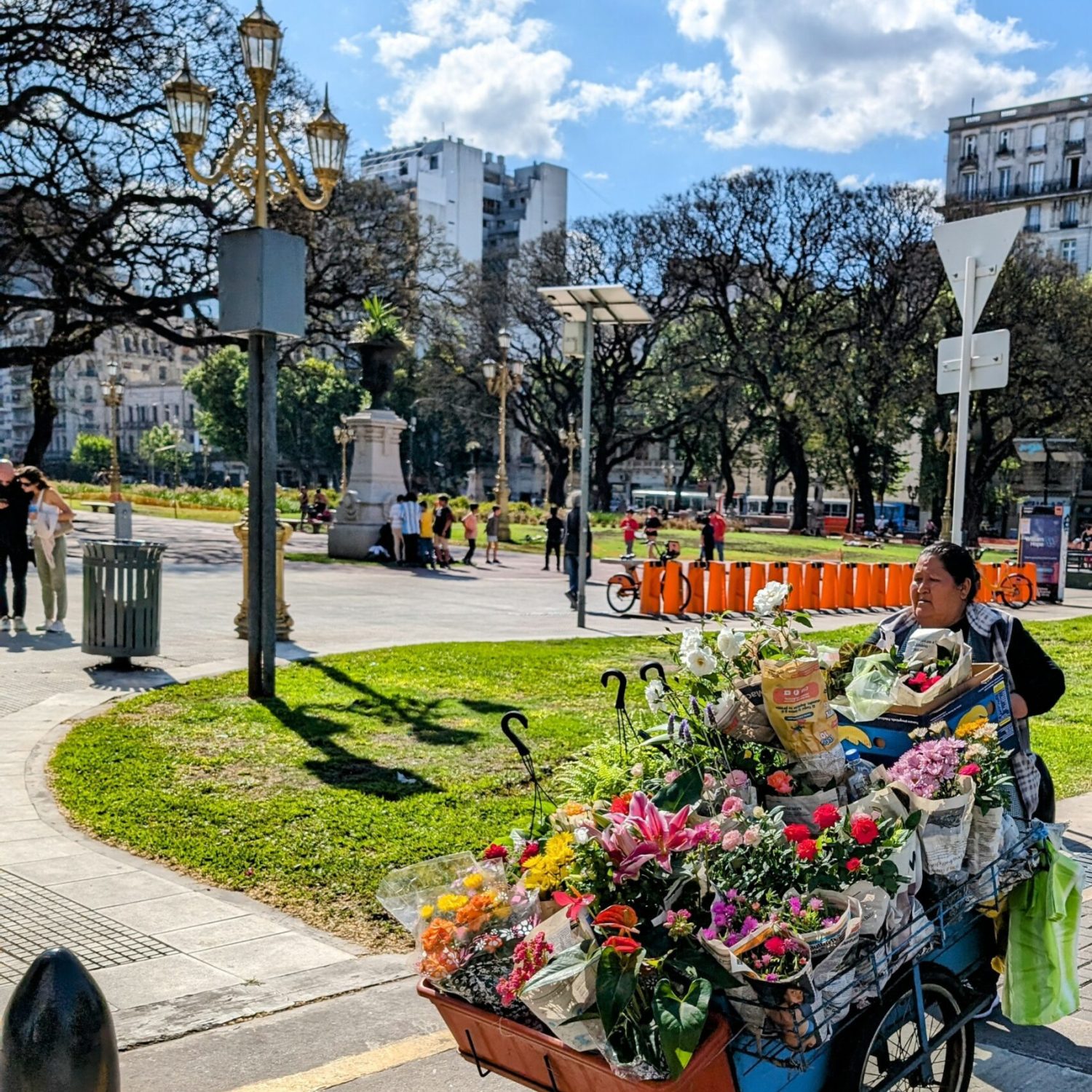 A woman pushing a wheelbarrow of flowers - free Buenos Aires walking tours