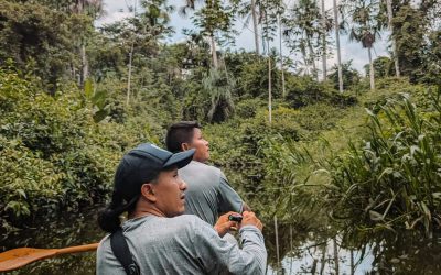 Two people rowing a canoe through the Amazon as part of an Amazon resort's offerings