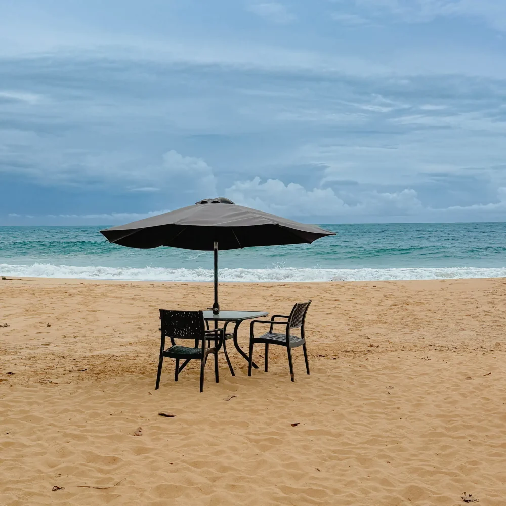 bocas-del-toro-beach-table-for-two Umbrella shading a table and two chairs on an empty beach in Bocas del Toro