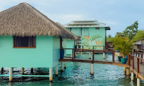 Turquoise over-water bungalows with thatched roofs at Sol Bungalows, Bocas del Toro