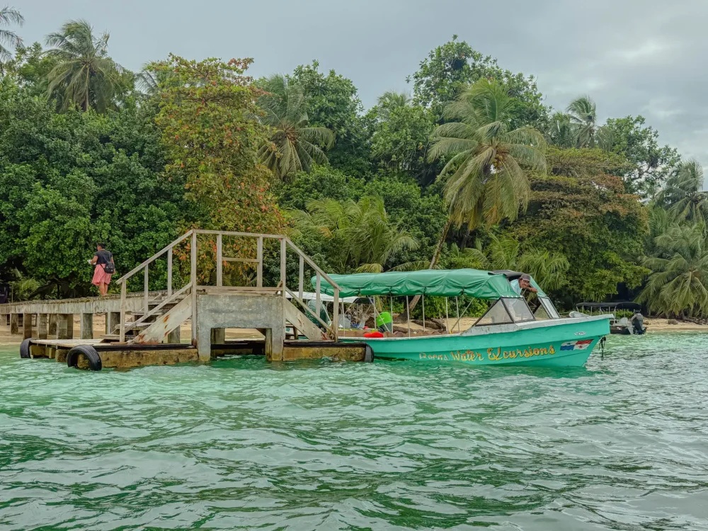 Green tour boat named Bocas Water Excursions at a dock in Bocas del Toro