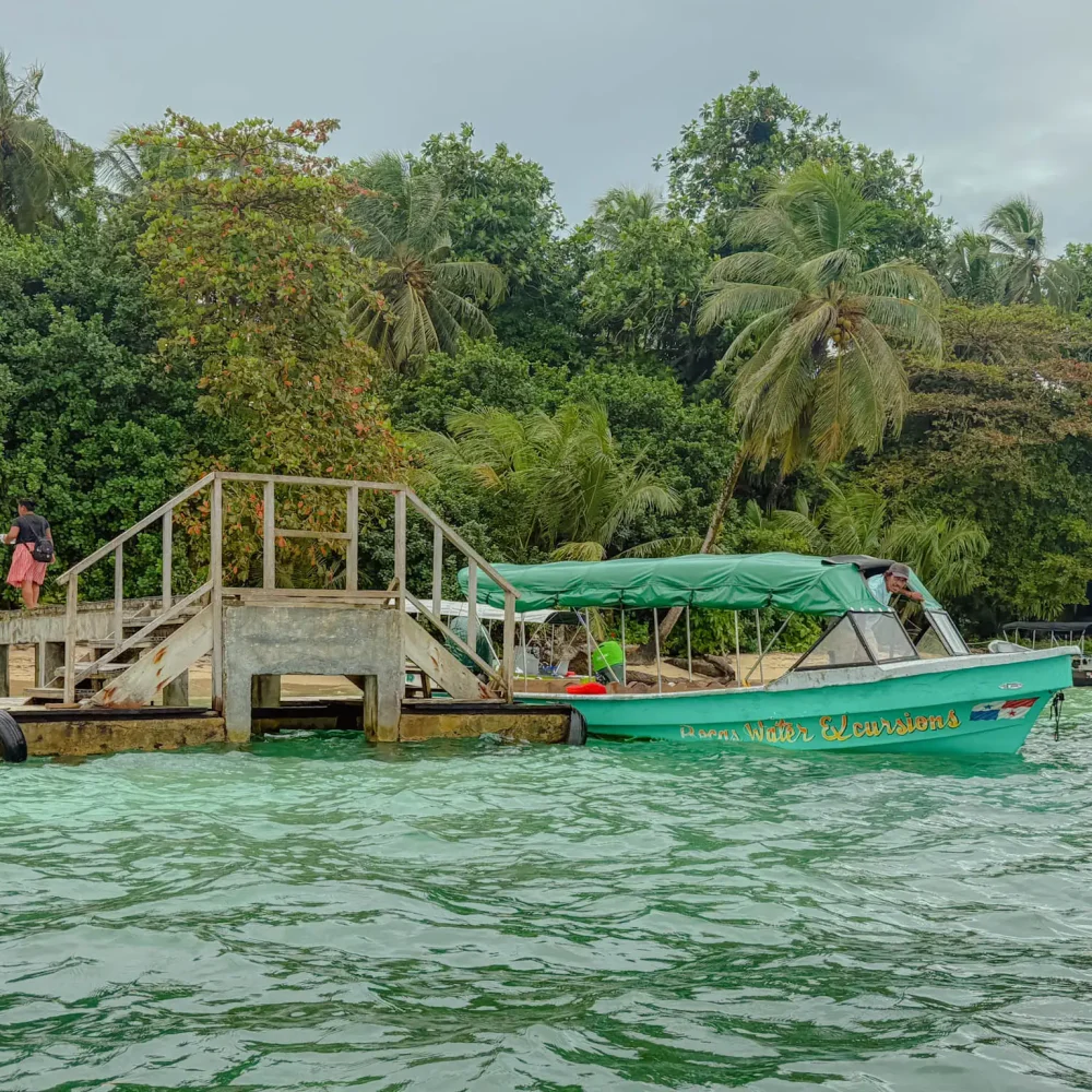 bocas-del-toro-water-excursion-boat Green tour boat named Bocas Water Excursions at a dock in Bocas del Toro