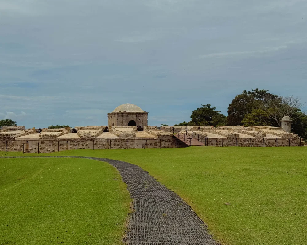fort-san-lorenzo-entrance-path-powder-magazine Path across a green lawn leading to the entrance gate and domed powder magazine of Fort San Lorenzo -- Portobelo Panama